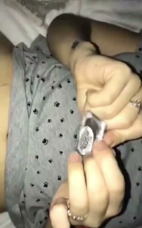 Amateur Male Holds Condom Packet in Paw Print Shorts