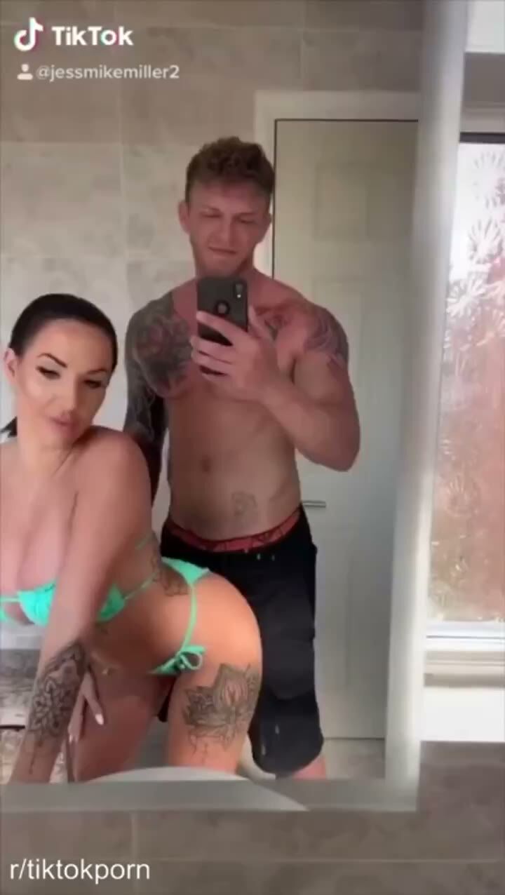 Tattooed Curvy Brunette in Bikini Poses With Muscular Man